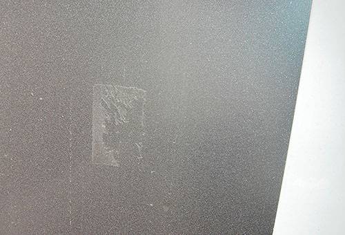 Kleberückstand von Klebeband auf Milchglas