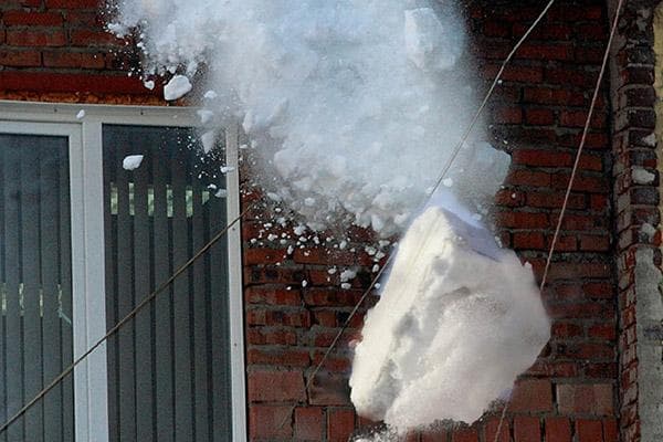 Schneemasse fällt vom Dach