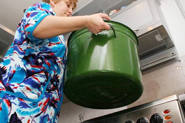 Frau hält einen Topf zum Kochen von Wäsche