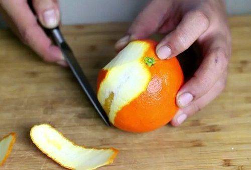 Orange mit einem Messer schälen