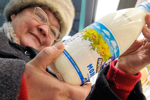 Rentnerin wählt Milch im Laden