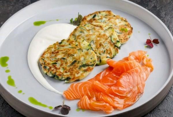 Zucchini-Kartoffelpuffer mit Fisch und weißem Joghurt.