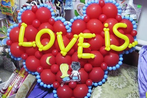 Herz mit dem Schriftzug „Love is“ aus Luftballons