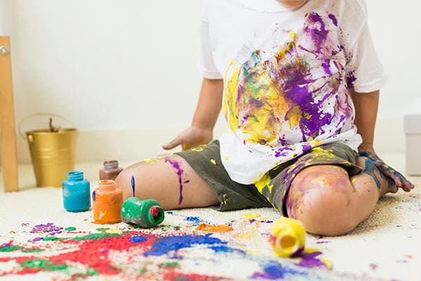 Kind hat Acrylfarben verschüttet