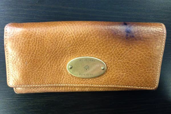 Fleck von einem Kugelschreiber auf einem Geldbeutel aus Leder