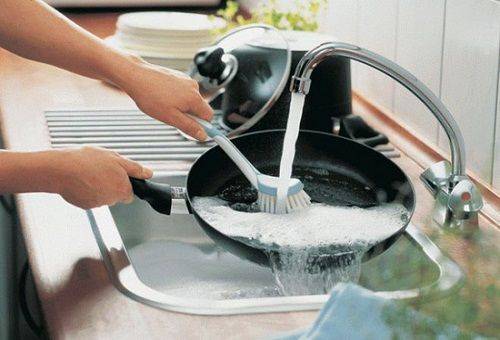 Spülen der Pfanne im Waschbecken