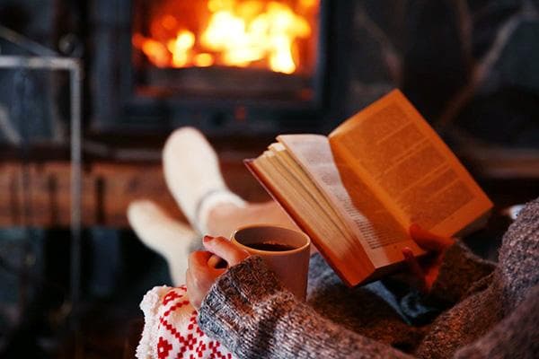 Buch am Kamin lesen