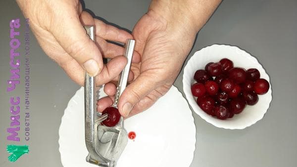Entfernen des Kerns aus der Beere mit einer Knoblauchpresse