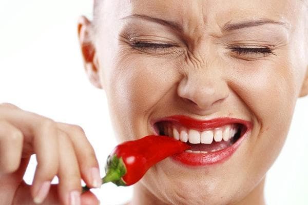 Eine Frau isst scharfen Chili