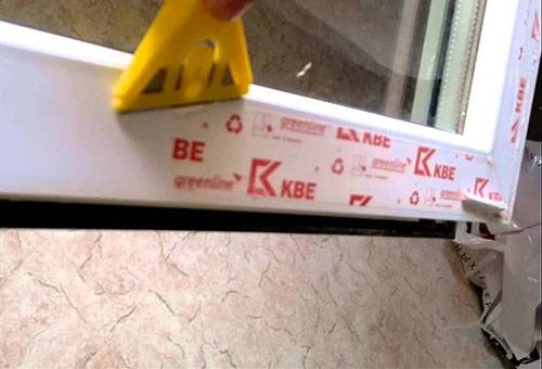 Entfernung der Folie vom Fenster mit einem Schaber