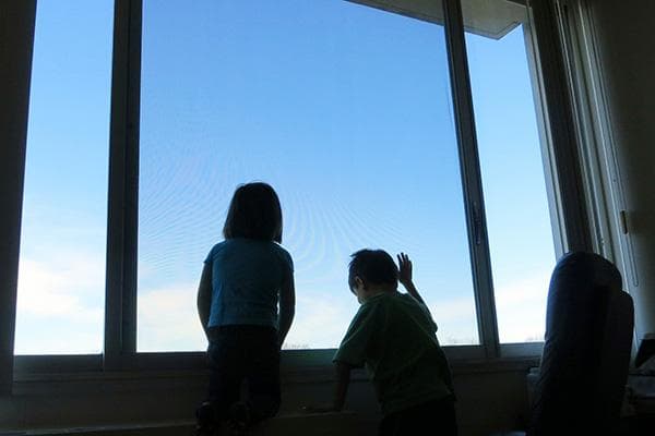Kinder am Fenster in einem hohen Stockwerk