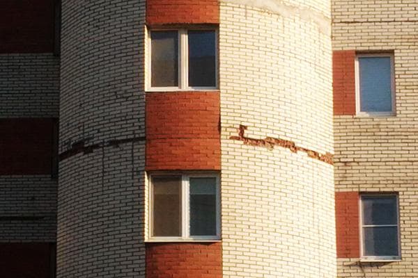 Ein Riss in der Fassade eines mehrstöckigen Backsteingebäudes