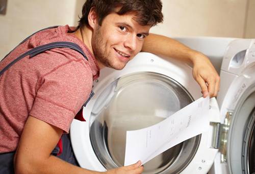 Ein Mann studiert die Gebrauchsanweisung einer Waschmaschine