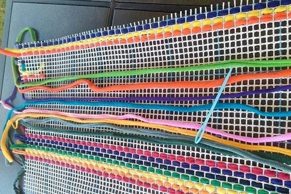 Flechten eines Teppichs auf einem Gitter