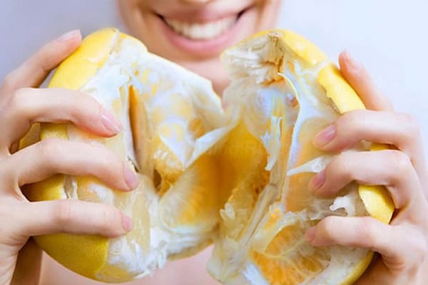 Junge Frau mit einer reifen Pomelo