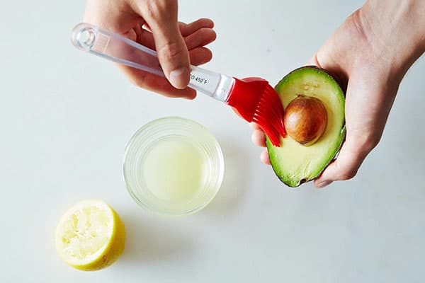 Bestreichen der Avocadohälfte mit Zitronensaft
