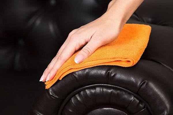 Abwischen eines Ledersofas mit Antistatikum