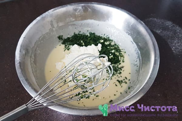 Kräuter und Käse zum Pfannkuchenteig hinzufügen