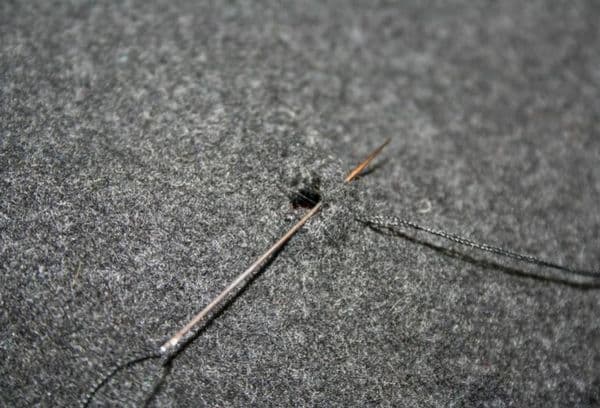 Reparatur von Kleidung mit Nadel und Faden