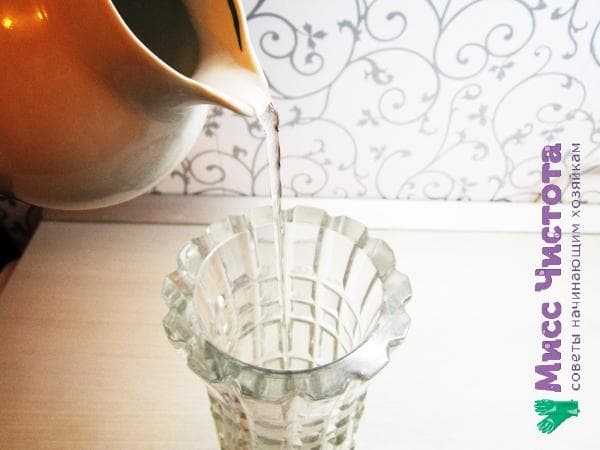 Wasser in die Kristallvase gießen