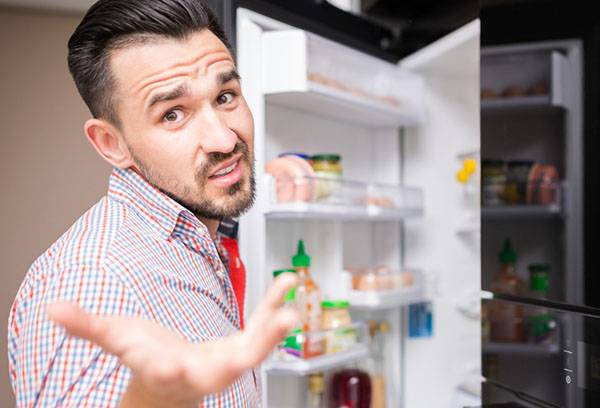 Mann ist unzufrieden mit dem Kühlschrank