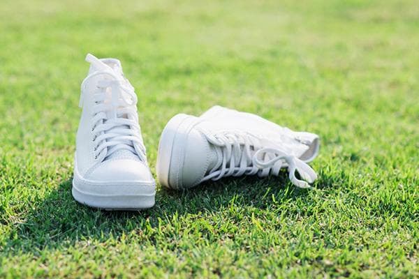 Weiße Sneakers auf dem Rasen
