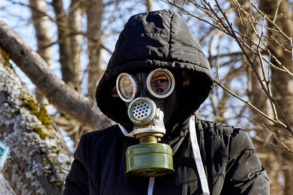 Frau in Jacke und Gasmaske