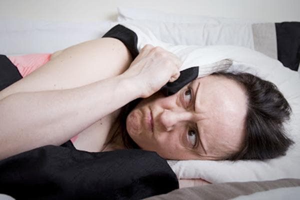 Lärm von den Nachbarn über ihr hindert eine Frau am Einschlafen