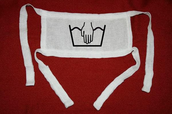 Selbstgemachter Mullverband und Symbol für Handwäsche