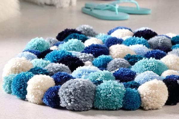 Pompon-Teppich in Blau- und Hellblautönen
