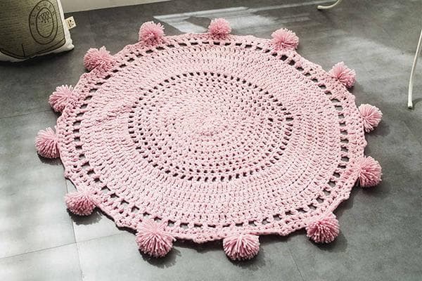 Gestrickter Teppich mit Pompons