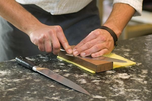 Un homme aiguise un couteau
