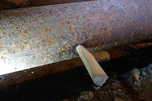 Beheben eines Rohrlecks mit einem Holzdübel