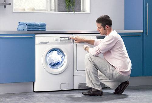 Ein Mann überprüft die Funktion der Waschmaschine