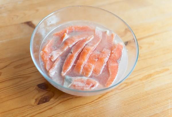 Auftauen von gefrorenem, gesalzenem Lachs in Wasser