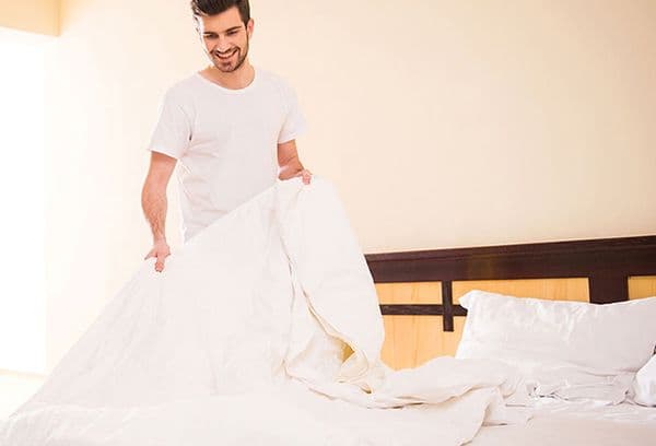 Mann macht das Bett
