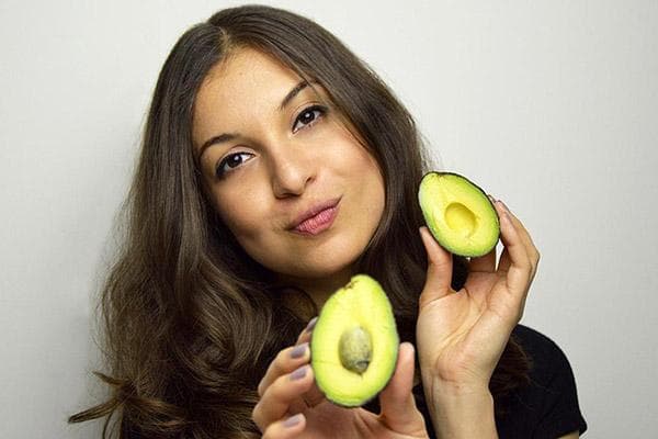 Eine Frau schneidet eine Avocado auf