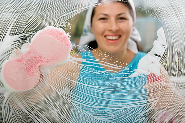 Eine Frau putzt Fenster