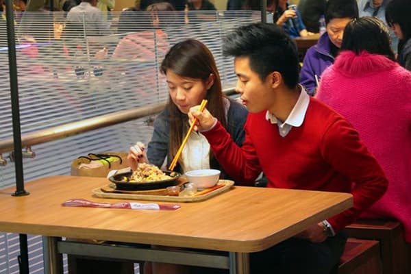 Asiaten essen aus einem Teller