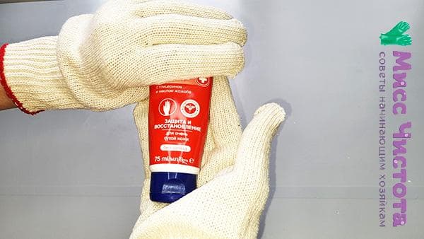 Hände mit Creme und in Handschuhen