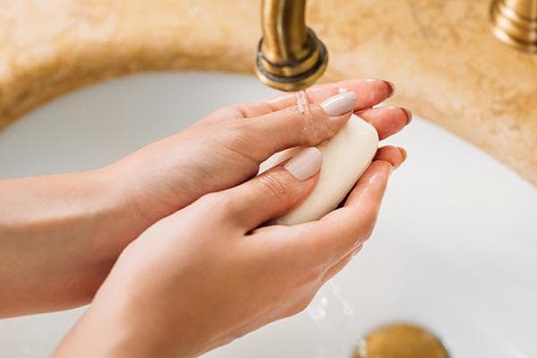 Eine Frau wäscht sich die Hände mit Toilettenseife