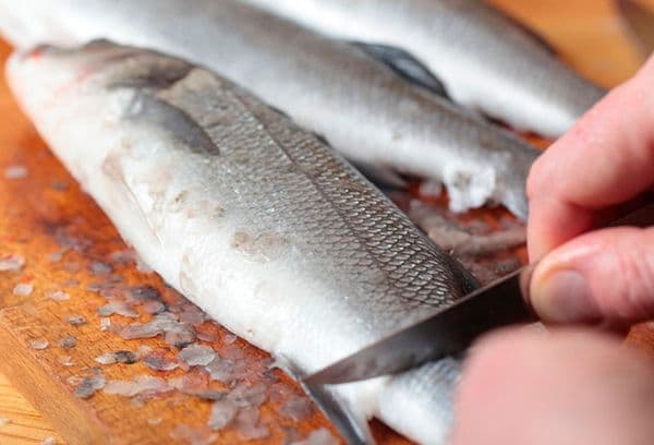 Reinigen des Fisches von Schuppen