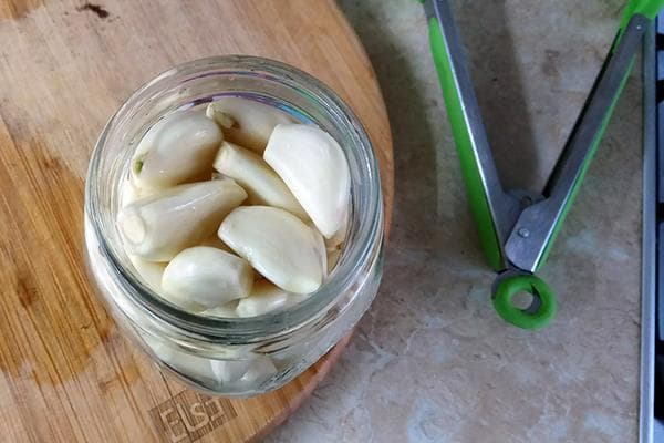 Knoblauchzehen in einem Glasgefäß