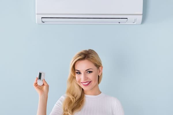 Frau unter der Klimaanlage