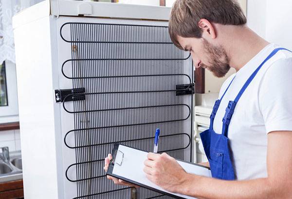 Ein Techniker führt eine Diagnose am Kühlschrank durch