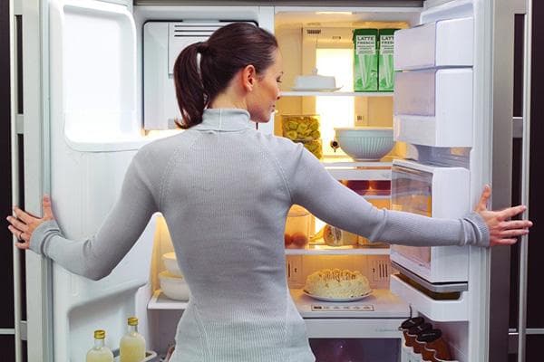 Frau am Kühlschrank mit Lebensmitteln