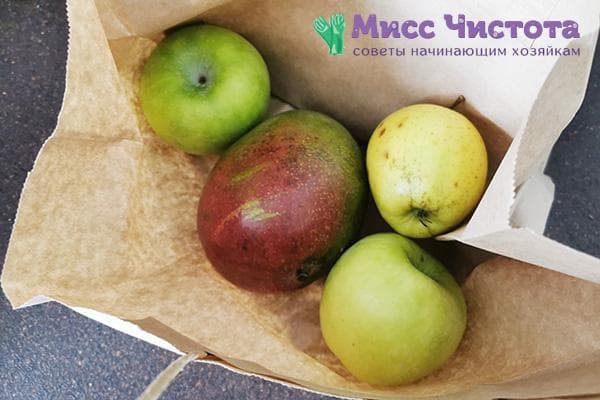 Mango in einer Papiertüte mit Äpfeln