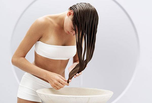 Junge wäscht sich die Haare in einem Kräutersud