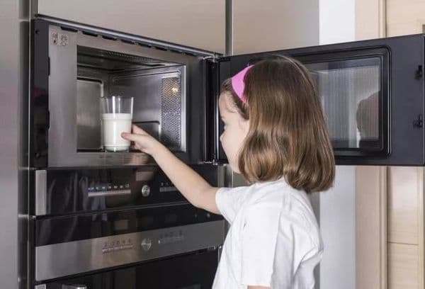 Mädchen erhitzt Milch
