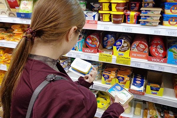 Frau wählt Schmelzkäse im Supermarkt aus